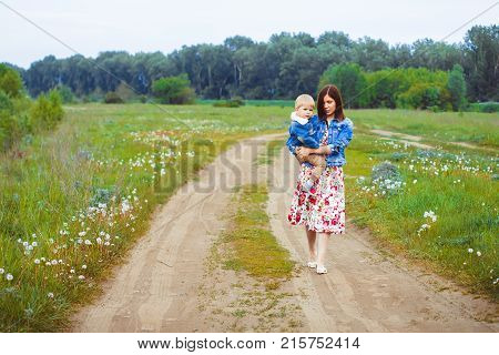 mother and son walking along a country road near the river