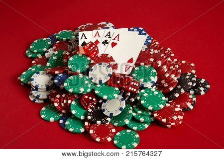 Poker cards and gambling chips on red background. Top view. Copy space. Still life. Flat lay. Cards - four aces. 4 of a kind