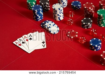 Poker cards and gambling chips on red background. Top view. Copy space. Still life. Flat lay. Cards - four aces. 4 of a kind