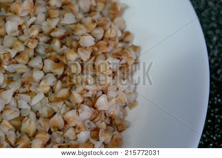 Buckwheat porridge in white plate. Healthy food.