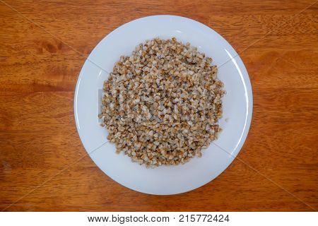 Buckwheat porridge in white plate. Healthy food.