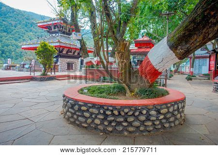 POKHARA, NEPAL - SEPTEMBER 04, 2017: Public jarden with a huge tree close to Tal Barahi Temple, located at the center of Phewa Lake, is the most important religious monument of Pokhara.