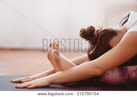 Yoga Concept. Close up woman meditates while practicing yoga in training hall or home.