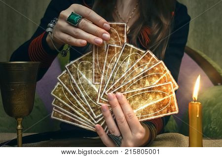 Tarot cards on fortune teller desk table. Future reading. Woman fortune teller holding and hands a deck of tarot cards and shuffles it.