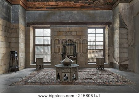 Cairo Egypt - November 25 2017: Hall at the palace of Prince Taz with stone bricks wall decorated by calligraphy with two windows historic chair and tables Old Cairo