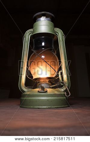 lit the old kerosene lamp standing on the table in crimson lights dim light a dark room