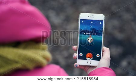 Samara, Russia - November 28, 2017: woman playing pokemon go on his iphone. pokemon go multiplayer game with elements of augmented reality.