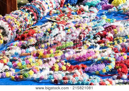 Many multi-colored floral handmade headbands saddle hair hairpins hairclips. Artificial color flowers headbands and hairpins for woman. Art handicraft creative concept