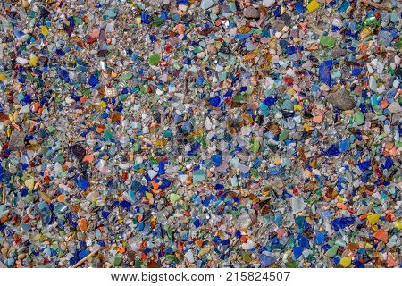 Colored pieces of rock and glass embedded in the ground.