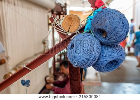 Balls of blue wool for weaving carpets and other equipment in background