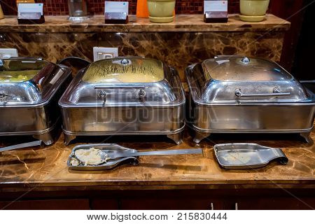 Close up metal containers with prepared dishes for buffet breakfast in hotel