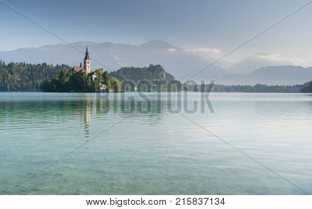 Colorful summer scene in the park of Bled town with medieval castle Blejski grad. White swans on Bled Lake. Morning in Julian Alpine. Slovenia Europe.
