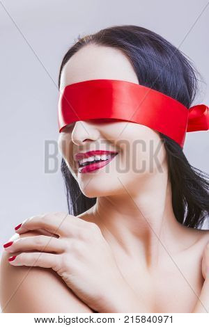 Caucasian Brunette Woman Posing with Red Ribbon Blinder on Eyes with Passionate Sensual Expression.Vertical Image