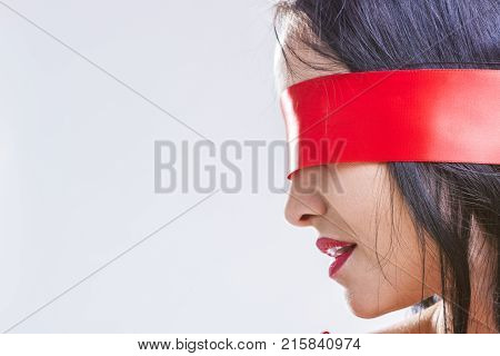 Caucasian Brunette Woman Posing with Red Ribbon Blinder on Eyes with Passionate Sensual Expression.Horizontal Image Composition