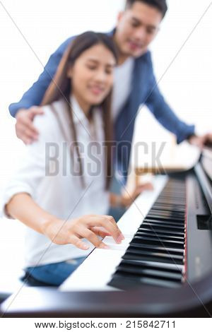 husband teaching his wife to play the piano concept for family relationship