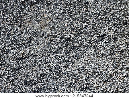 Granite gravel of macadam rock gray crushed for construction on the ground scree texture background.