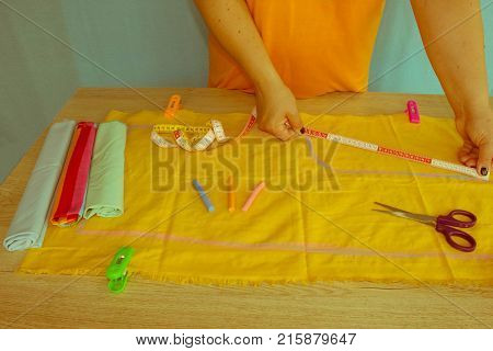Tailor woman working in his tailor shop Tailoring. A tailor is laying out a dress/Sewing layout