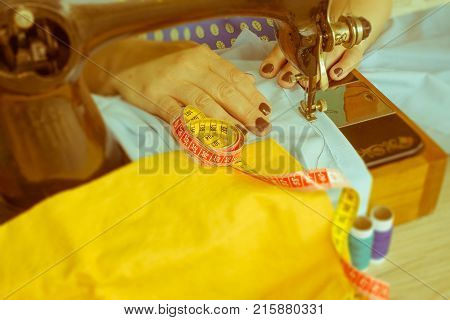 closeup of woman hands sewing yellow cloth outdoors. Woman's Hand Sewing Quilt