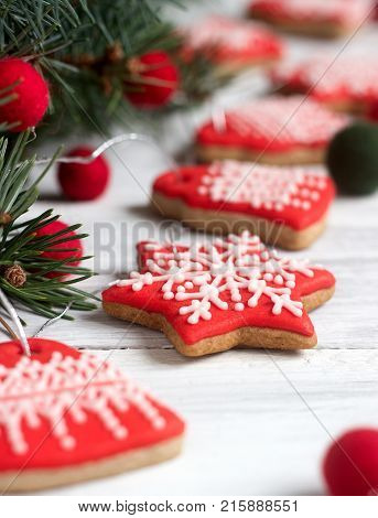 Gingerbread bells and stars, a garland of felted beads and fir branches on a light background - a Christmas or New Year's card. Selective focus.