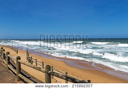Wooden Pole Barrier On Beachfront Against Coastal  Landscape