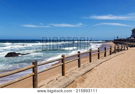 Wooden Pole Barrier On Beachfront Against Coastal  Landscape