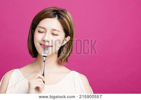 young woman holding fork and enjoy tasty food