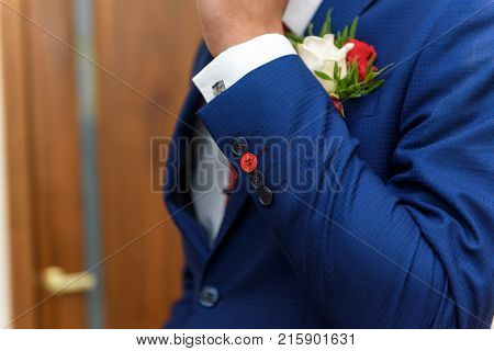 groom in a jacket, boutonniere on a jacket, the groom adjusts his jacket, The morning of the groom, business style, man in a jacket.