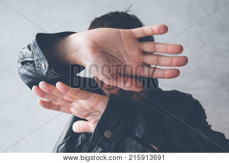 Celebrity male hiding face with hands from paparazzi photographers no photos gesture