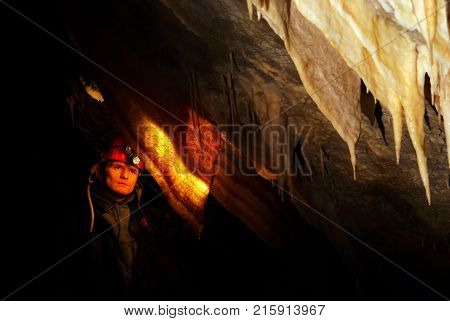 Spelunker wondering in a beautiful cave with stalactites