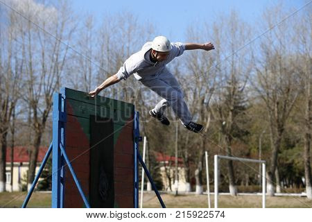 Belarus the city of Gomel 12.04.2017. Open lesson on fire fighting.Jump over the obstacle course.The athlete jumps over the barrier.Physical education lesson.