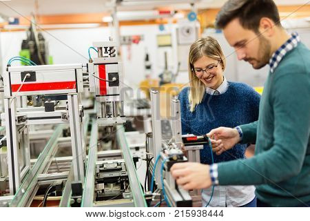 Young attractive students of mechatronics working on project together