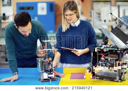 Young attractive students of mechatronics working on project together