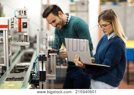 Young attractive students of mechatronics working on project together