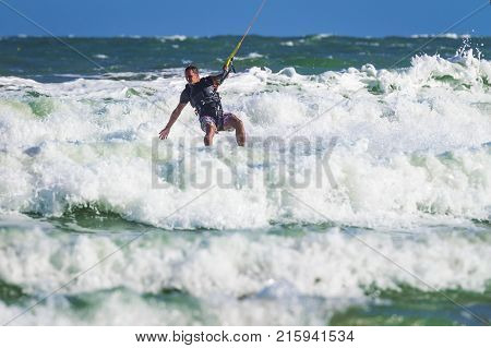Young Atletic Man Riding Kite Surf On A Sea