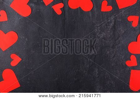 Hearts carved, red of different sizes lying along the perimeter of the arch are shown not completely on a stone background