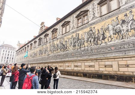 DRESDEN GERMANY - OCTOBER 20 2017: Tourists admiring Fürstenzug Procession of Princes mural in Dresden. It is one of the main tourist attraction in the city. Editorial.