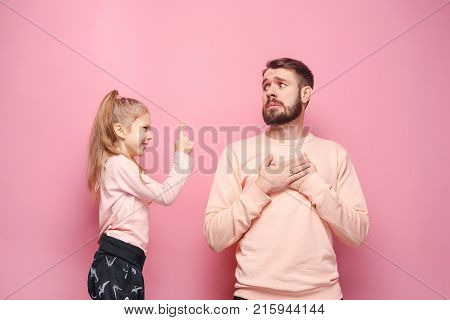 Young father with his baby daughter. The kid in preschool age pointing with finger and scolding father