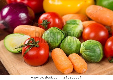 Assortment of fresh vegetales on wooden table, healthy nutrition background