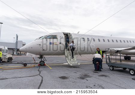 HELSINKI FINLAND - AUGUST 17 2017: Passenger climbing the stairs of SAS airplane before departure. Scandinavian Airlines is the largest airline in Norway Sweden and Denmark. Editorial.