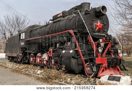 Kazakhstan Ust-Kamenogorsk november 2 2017: Old soviet locomotive next to the railway station. The station 