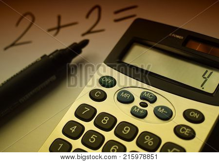 der Rechner liegt auf dem Tisch neben dem Marker und Papier