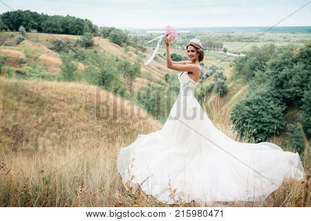 Portrait Of A Young Beautiful Bride On A Background Of A Gorgeous View Of The River And Fields.