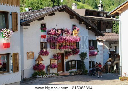 Italy Rocca Pietore - August 26 2016: the view of the typical white house with flowers in Rocca Pietore on August 26 2016 Veneto Italy.