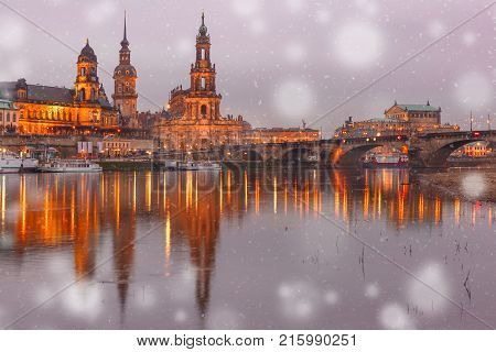 Dresden Cathedral of the Holy Trinity or Hofkirche, Bruehl's Terrace or The Balcony of Europe, Semperoper and Augustus Bridge with reflections in the river Elbe at snowy christmas night in Dresden, Saxony, Germany