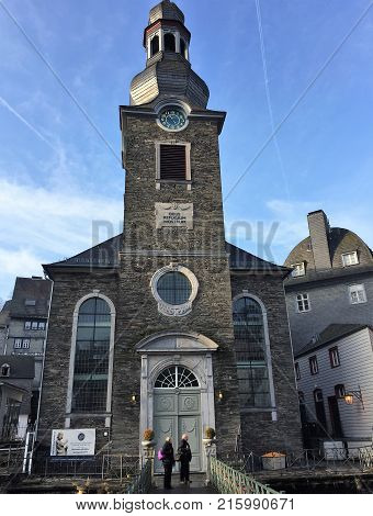 Monschau, Germany - December 17, 2016: Historic Church in Monschau, Germany. Travel scene with tourists.