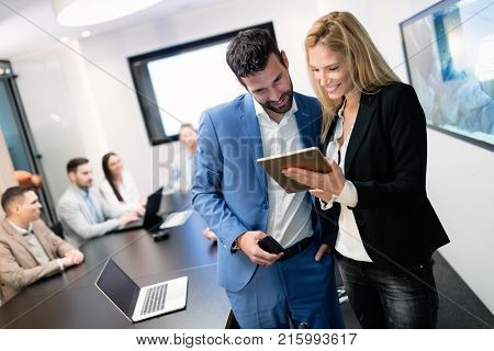 Attractive business couple working on tablet in modern office together