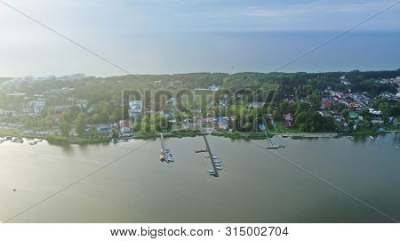 Drone Aerial Perspective View On Touristic City Located On Narrow Spit Between Sea And Lake With Yac
