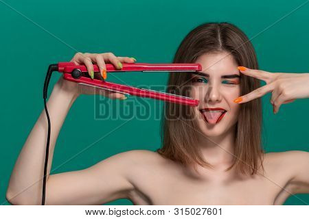 Portrait Of Beautiful Young Woman With Bright Color Make-up Doing Hair Style Herself With A Purple S