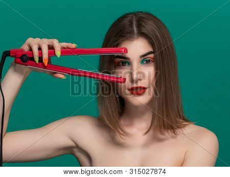 Portrait Of Beautiful Young Woman With Bright Color Make-up Doing Hair Style Herself With A Purple S