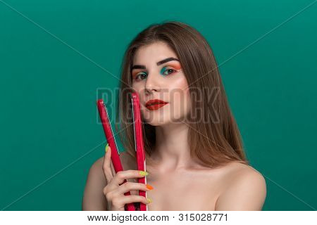 Portrait Of Beautiful Young Woman With Bright Color Make-up Doing Hair Style Herself With A Purple S